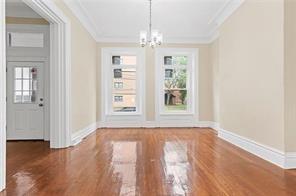 1005 Sheffield Street Pittsburgh, PA 15233 - Photo 5 of 11 an empty room with wooden floor chandelier and windows
