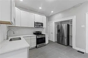 a kitchen with stainless steel appliances granite countertop a refrigerator sink and stove