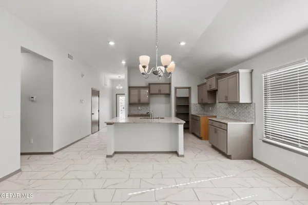 a large white kitchen with a large window and stainless steel appliances