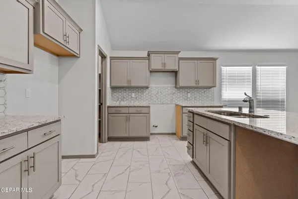a kitchen with granite countertop a sink stove and cabinets
