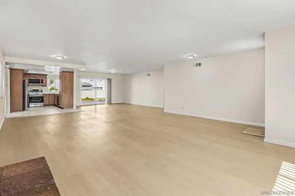a view of an empty room with kitchen