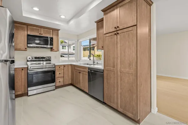 a kitchen with stainless steel appliances a refrigerator sink and microwave