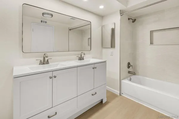a bathroom with a tub a sink and mirror