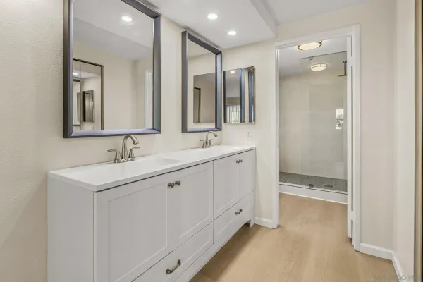 a bathroom with a double vanity sink mirror and shower
