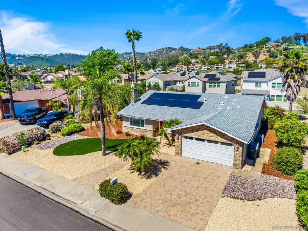 an aerial view of residential houses with outdoor space and trees