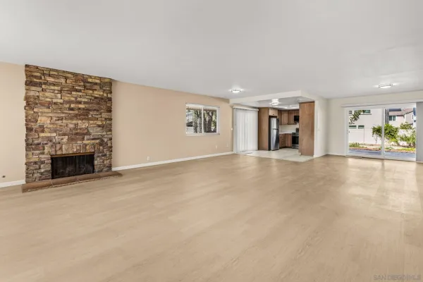 an empty room with fireplace and a window
