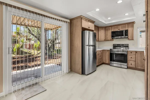 a view of a kitchen with stainless steel appliances granite countertop a refrigerator and a sink