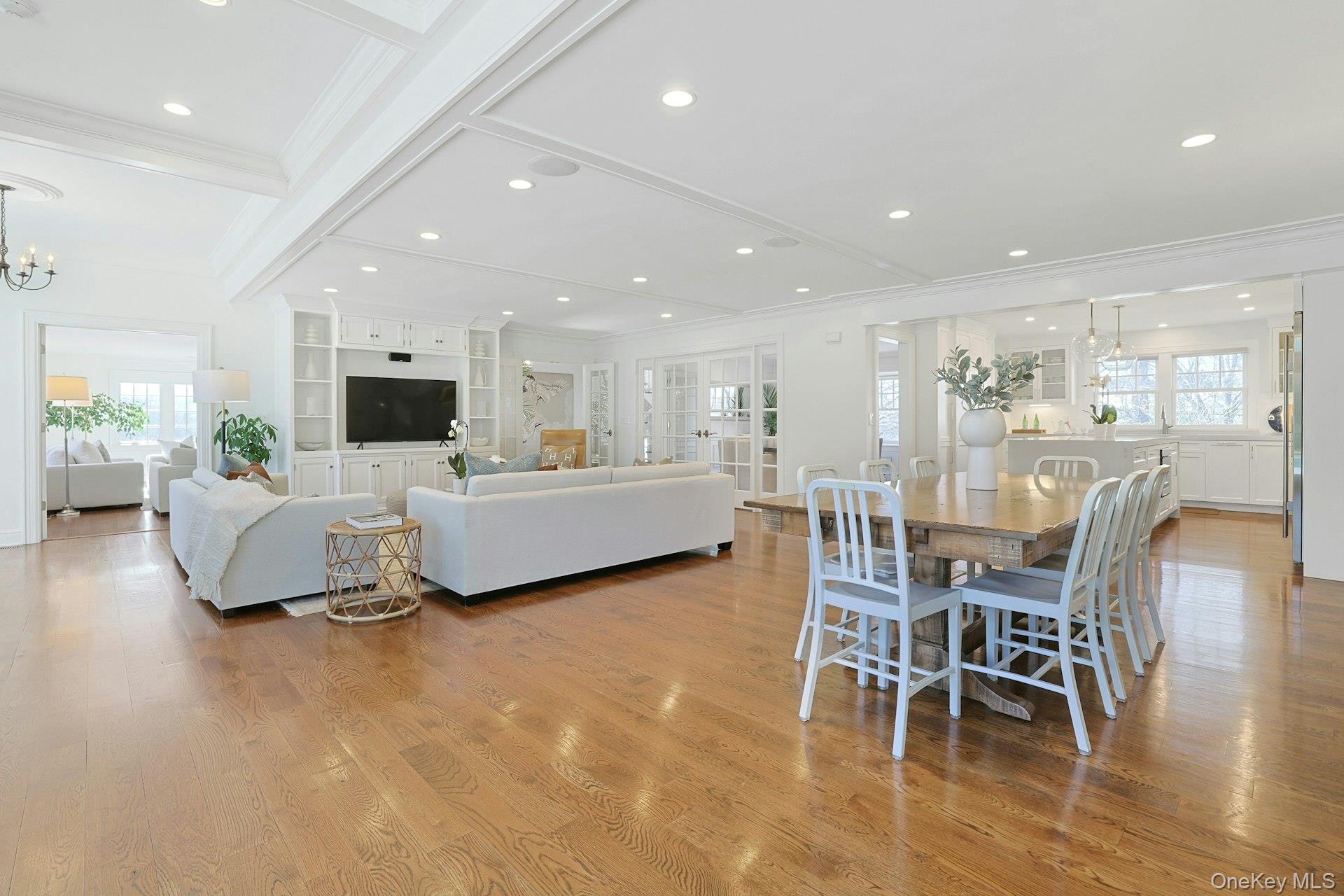 369 Evandale Road Scarsdale, NY 10583 - Photo 17 of 49 Final view of the open great room, showcasing the dining area, living space, and coffered ceilings.