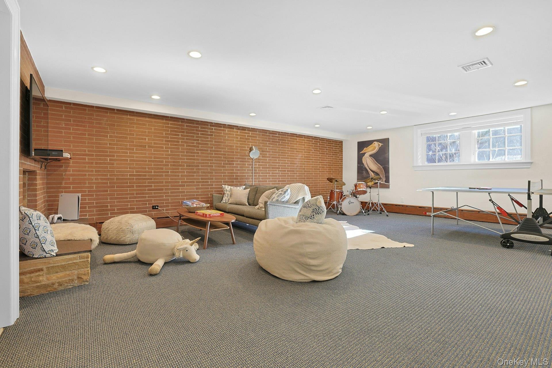 369 Evandale Road Scarsdale, NY 10583 - Photo 33 of 49 Lower level recreation room with a decorative (non-working) fireplace and plenty of room for games, lounging, and everyday fun.