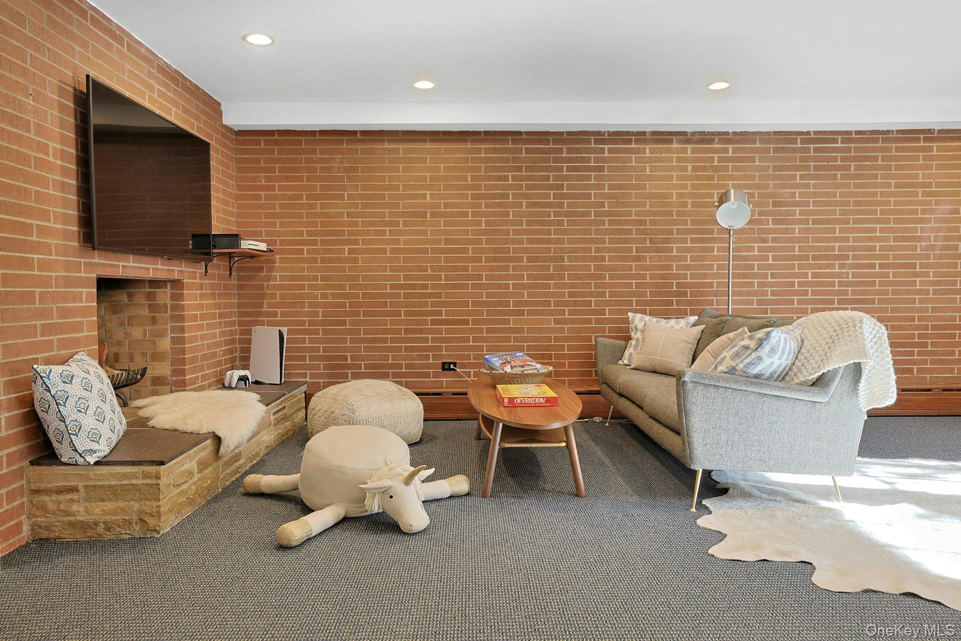 369 Evandale Road Scarsdale, NY 10583 - Photo 34 of 49 Closer view of the play and lounge area featuring the decorative fireplace.