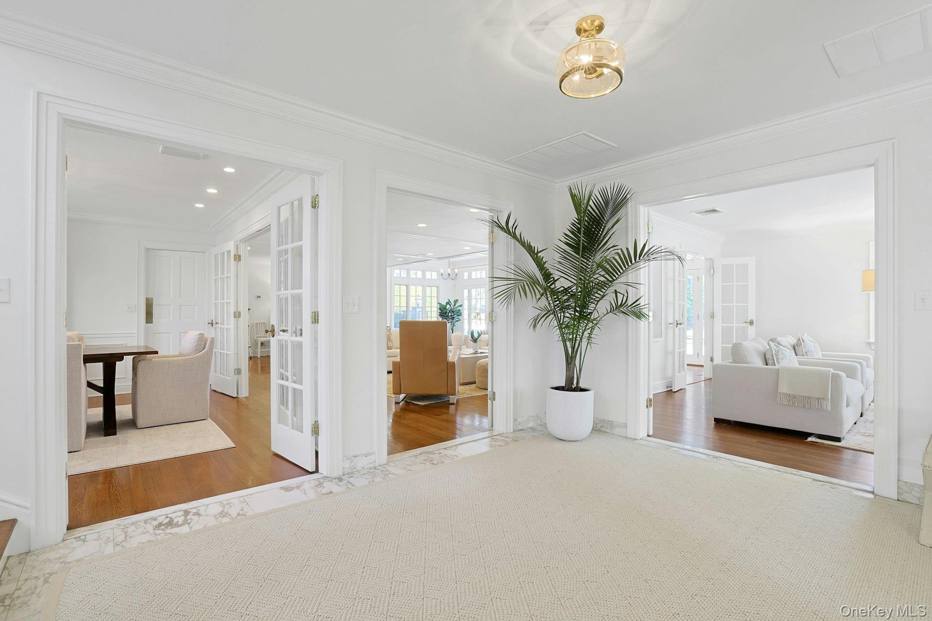 369 Evandale Road Scarsdale, NY 10583 - Photo 5 of 49 A welcoming entry opens to a grand foyer, showcasing Calcutta Gold marble floors and beautiful sightlines throughout, with a powder room and spacious closet nearby.