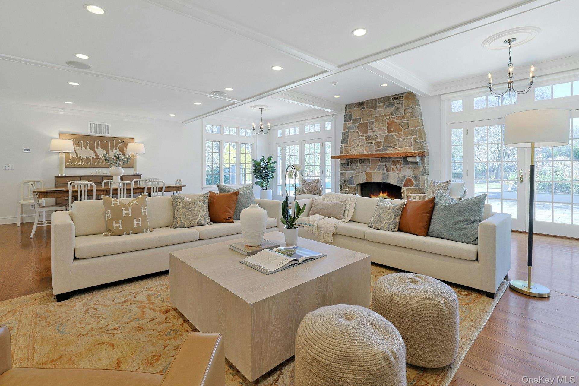 369 Evandale Road Scarsdale, NY 10583 - Photo 9 of 49 The standout main living area is the oversized open plan kitchen, dining area, and family room, featuring coffered ceilings and two sets of French doors opening to the patio, pool, and expansive yard. The family room is enhanced by custom built ins and a striking floor to ceiling stone fireplace.