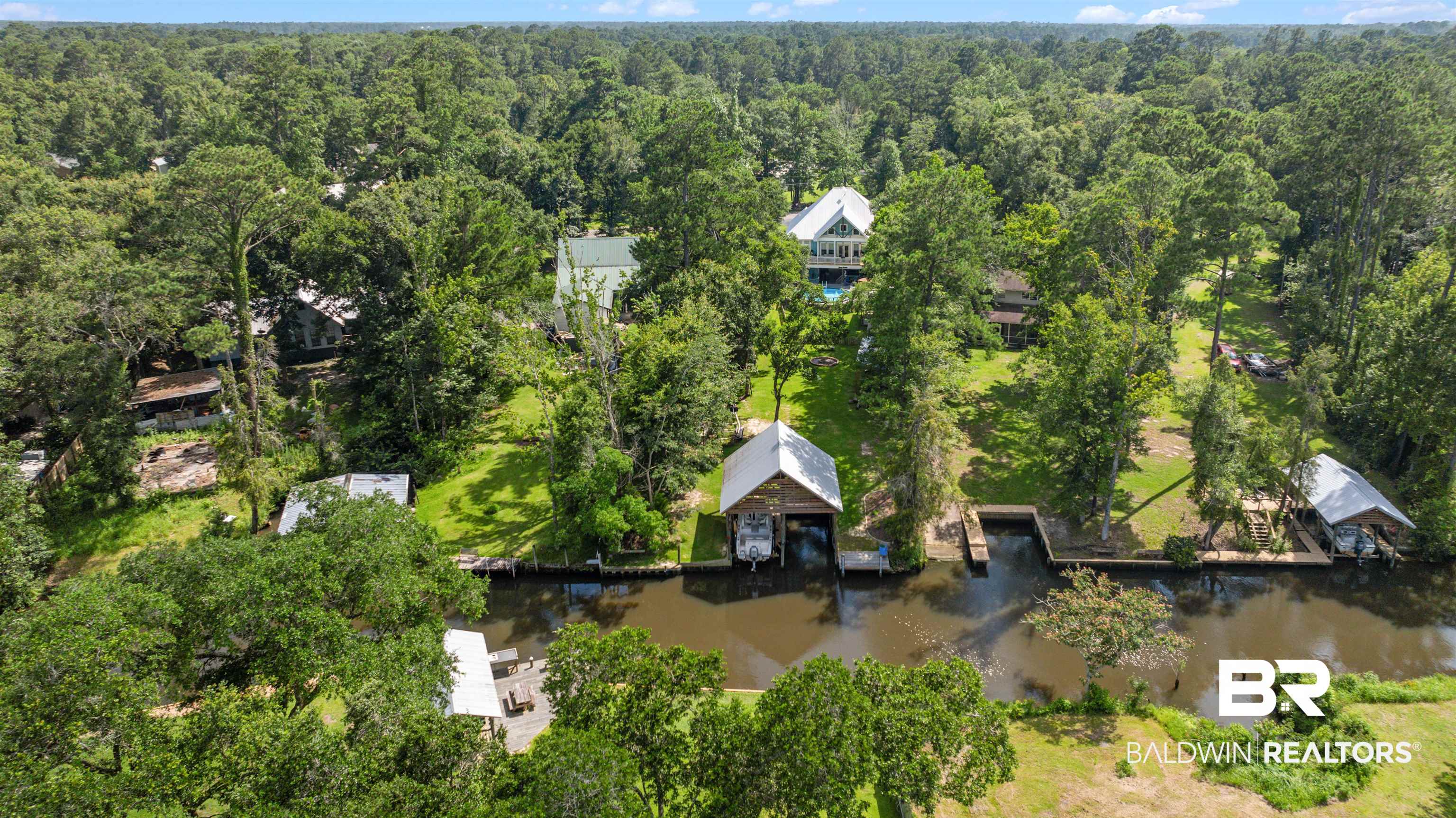 7266 Franklin Road Foley, AL 36535 - Photo 7 of 64 Waterfront property featuring multiple boat houses, private docks, and a mature treed landscape