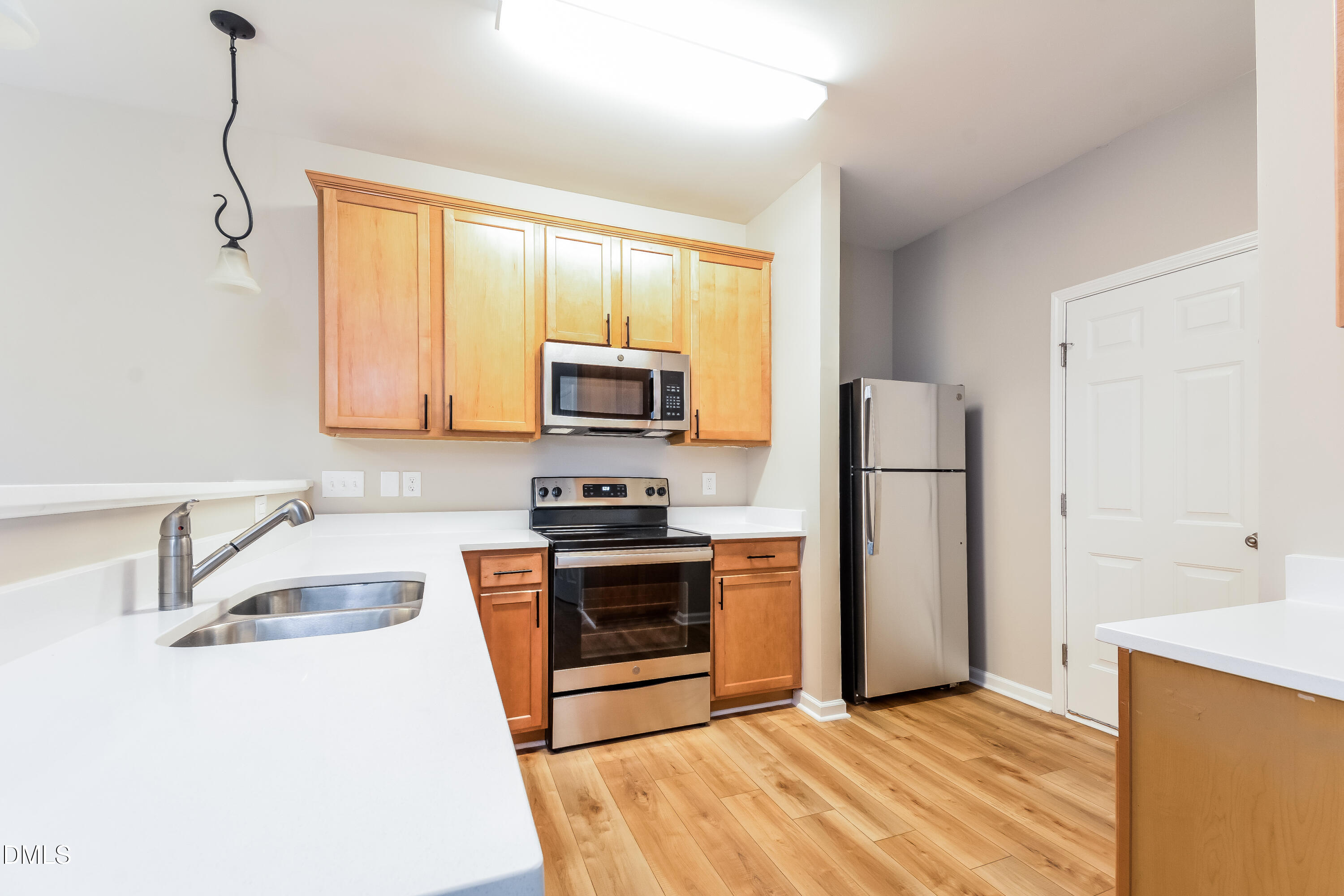 1413 Cozart Street Durham, NC 27704 - Photo 4 of 17 a kitchen with stainless steel appliances granite countertop a sink a stove a refrigerator with white cabinets and wooden floor