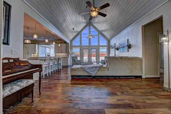 a spacious bedroom with a bed a table and large windows