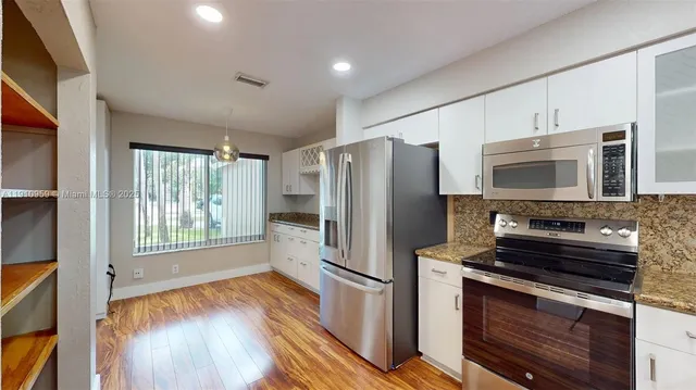 a kitchen with stainless steel appliances a refrigerator stove and microwave