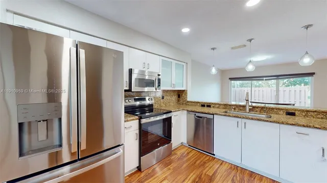 a kitchen with stainless steel appliances granite countertop a refrigerator and a stove top oven