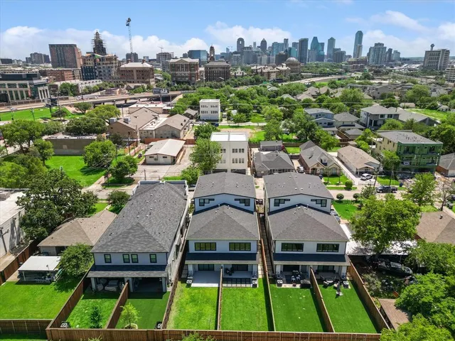 an aerial view of multiple houses with yard