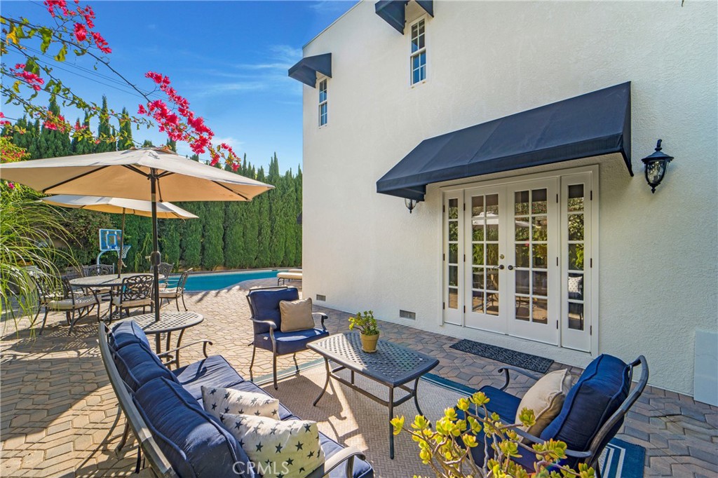 a view of a patio with a dining table and chairs under an umbrella