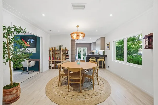 a dining room with furniture a large window and a chandelier