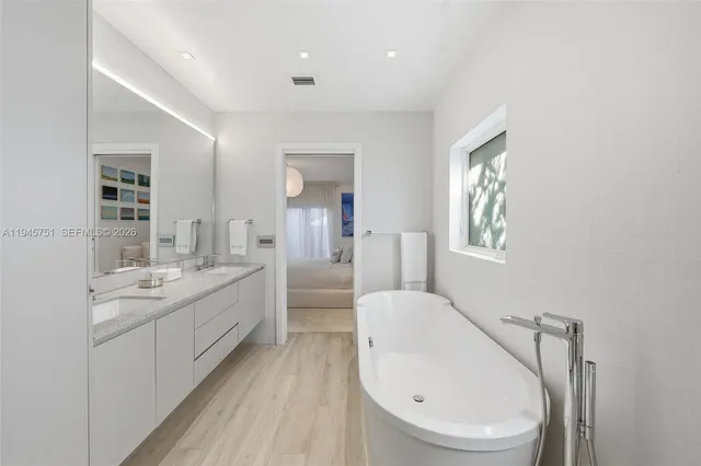 a bathroom with a granite countertop sink mirror bathtub and toilet