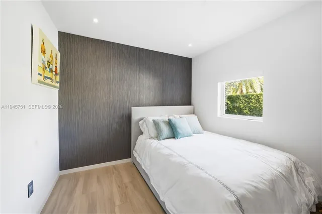 a bedroom with a bed and painting on the wall