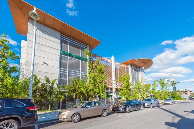 a front view of a house with plants and palm trees