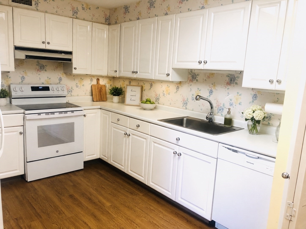 402 Paradise Road, Unit 2L Swampscott, MA 01907 - Photo 2 of 11 a kitchen with cabinets stainless steel appliances a sink and wooden floor