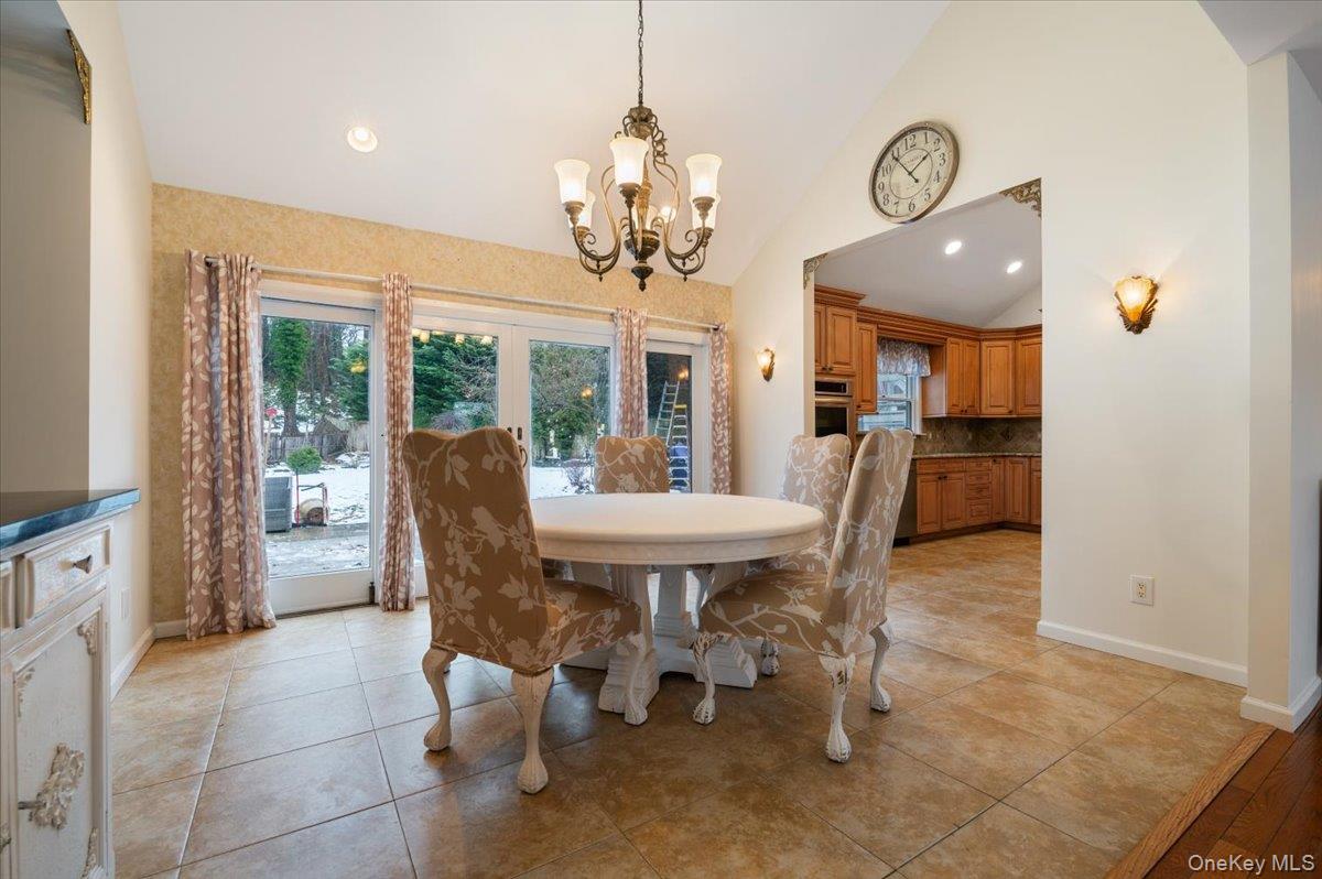 33 Fleets Cove Road Huntington, NY 11743 - Photo 11 of 42 Dining room featuring light tile patterned floors, high vaulted ceiling, recessed lighting, and a chandelier