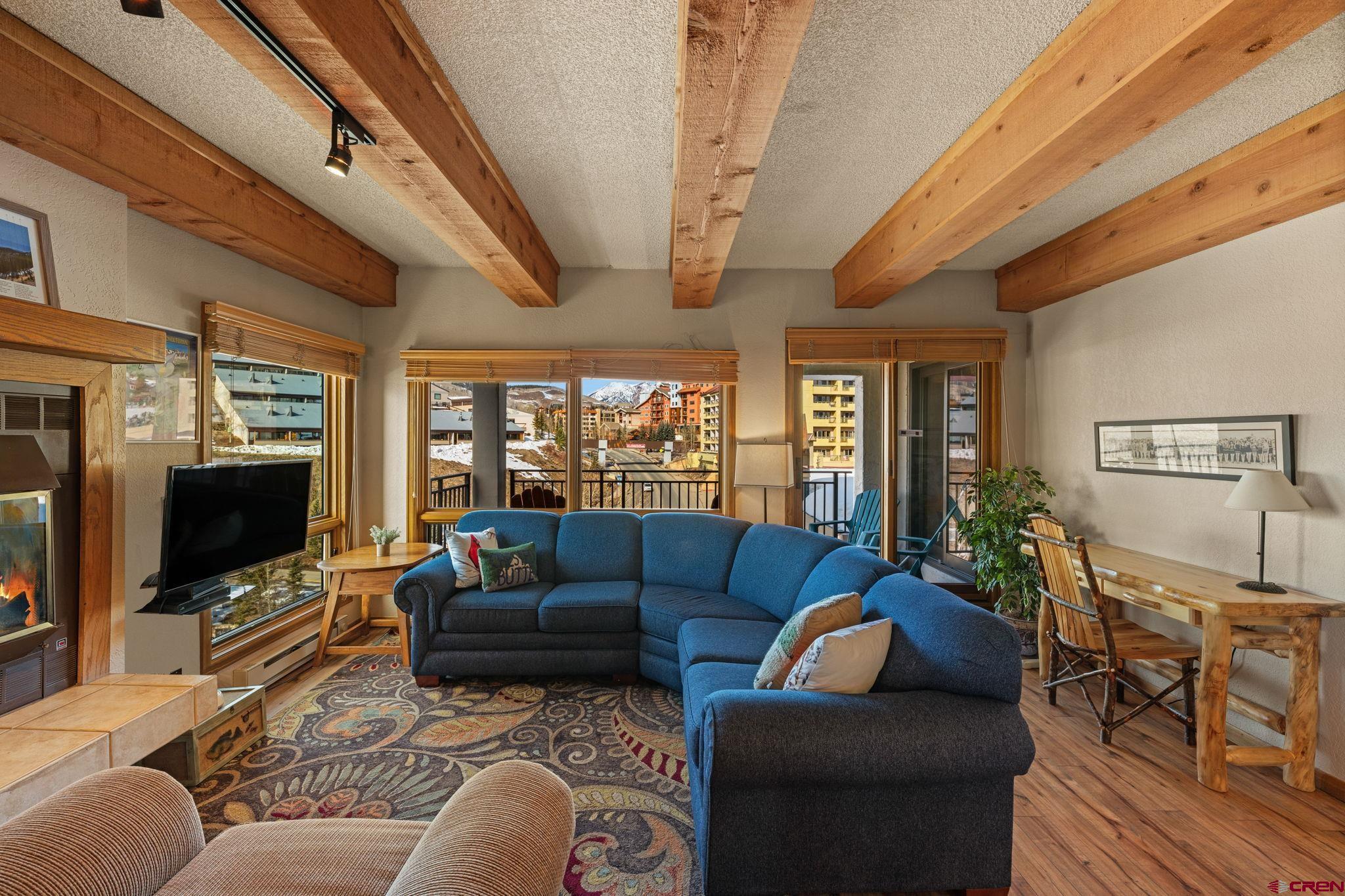 11 Snowmass Road, Unit 638 Crested Butte, CO 81225 - Photo 1 of 41 a living room with furniture a flat screen tv and a floor to ceiling window