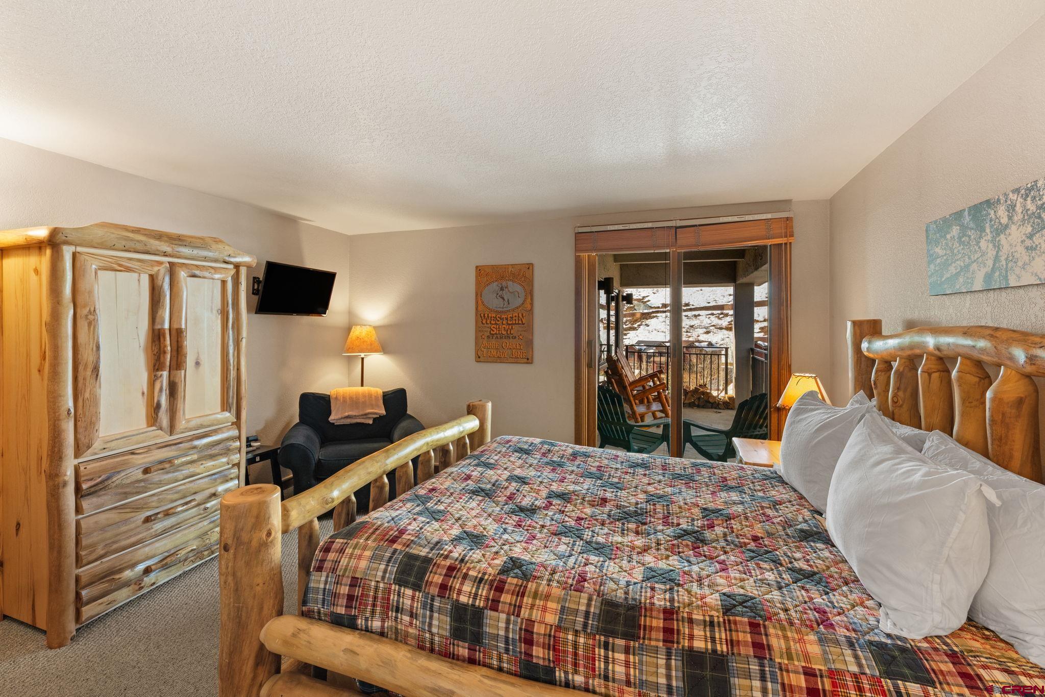 11 Snowmass Road, Unit 638 Crested Butte, CO 81225 - Photo 28 of 41 a bedroom with a bed and wooden floor