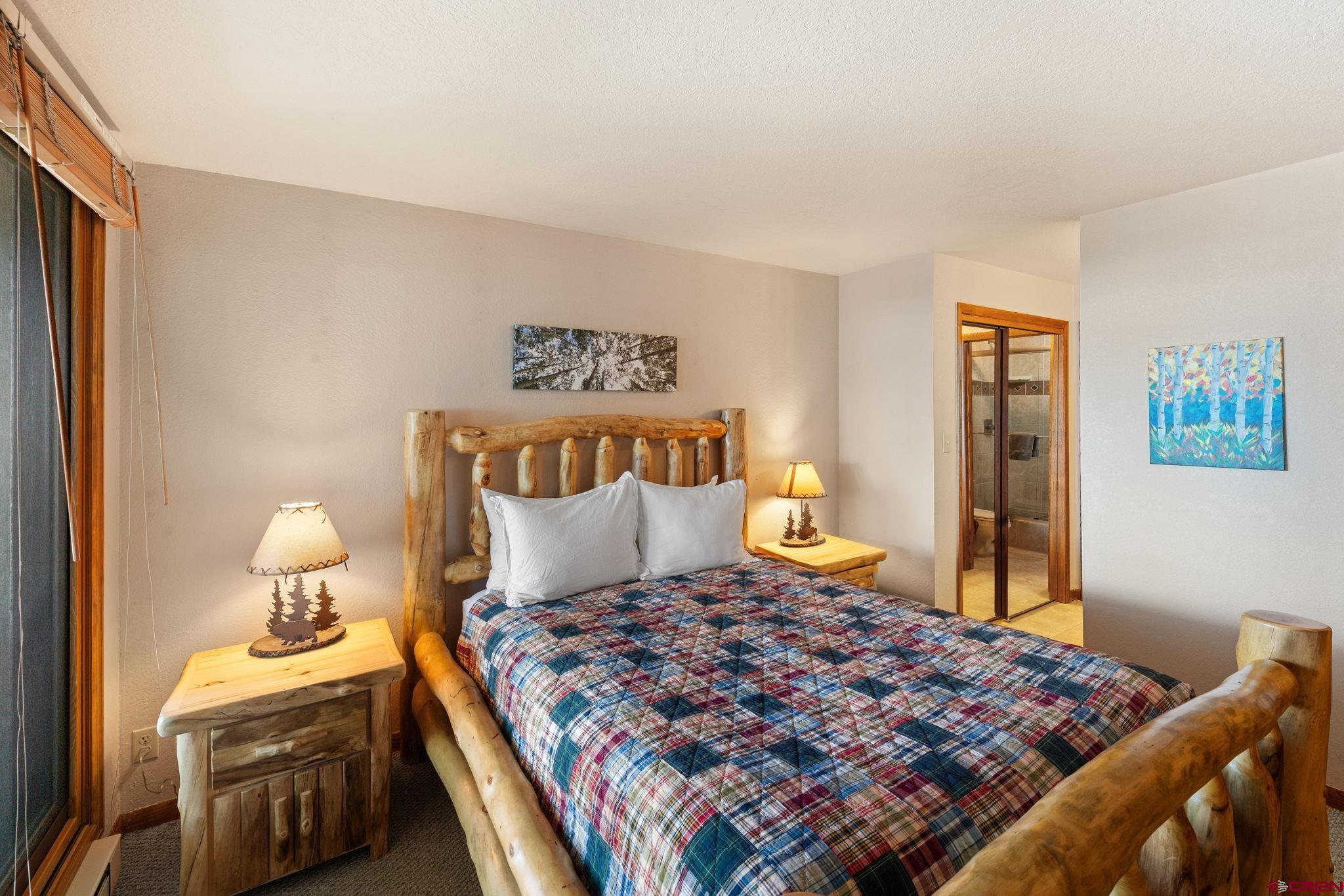 11 Snowmass Road, Unit 638 Crested Butte, CO 81225 - Photo 31 of 41 a bedroom with a bed and wooden floor