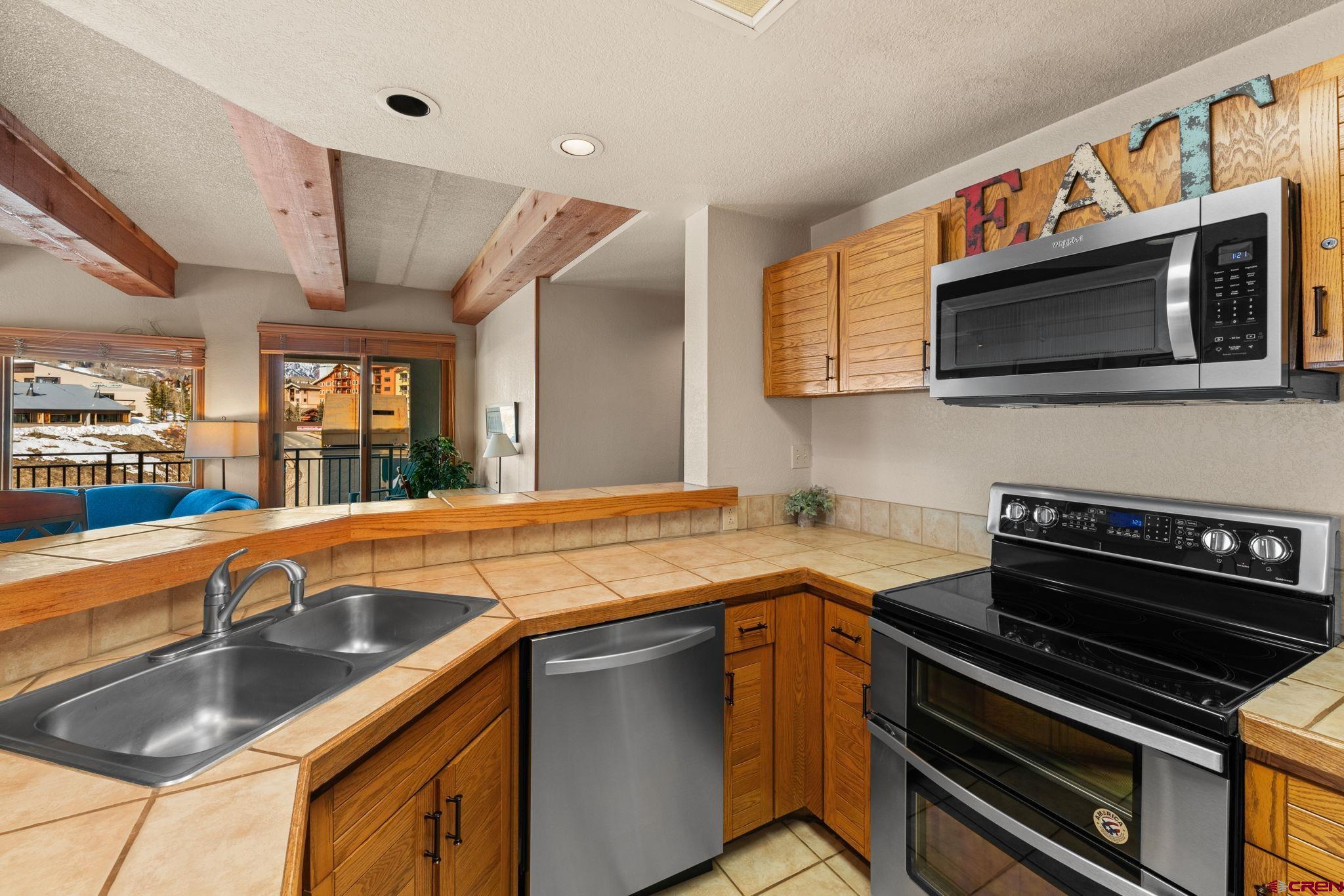 11 Snowmass Road, Unit 638 Crested Butte, CO 81225 - Photo 4 of 41 a kitchen with stainless steel appliances a sink cabinets and a stove top oven