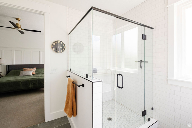 924 Country Lane Farmington, UT 84025 - Photo 30 of 91 Glass-enclosed shower featuring black-framed clear glass panels, white subway tile walls, and a hexagonal tile floor