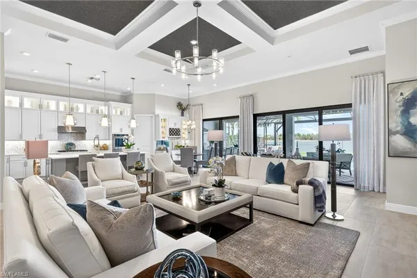 a living room with furniture kitchen view and a chandelier