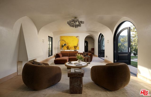 a living room with fireplace furniture and a potted plant