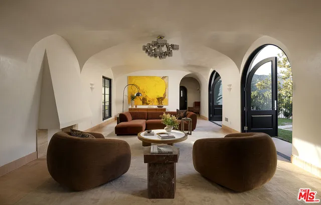 a living room with fireplace furniture and a potted plant