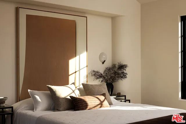 a bedroom with a bed and a large window