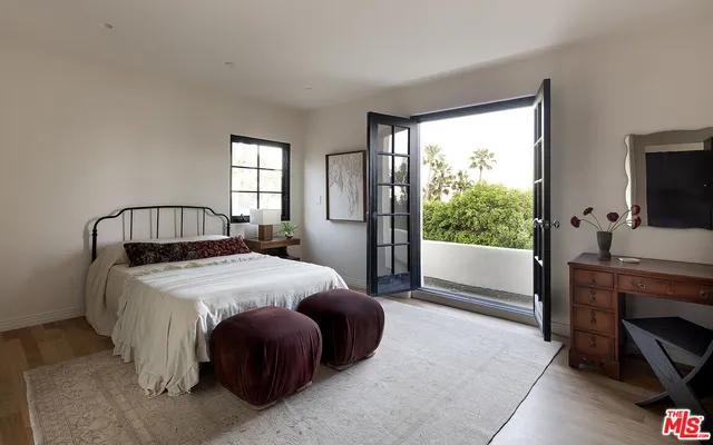 a bedroom with a large window and bed