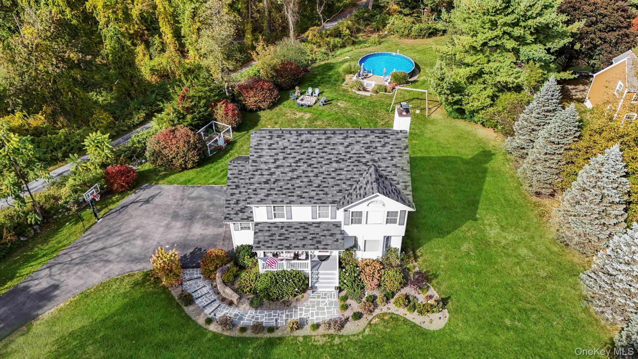 a aerial view of a house with a yard basket ball court and outdoor seating