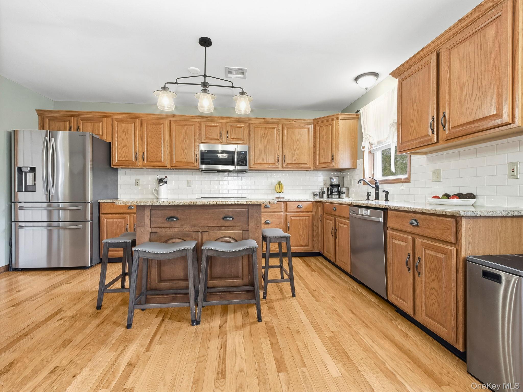 90 Reilly Road LaGrangeville, NY 12540 - Photo 29 of 50 a kitchen with stainless steel appliances granite countertop a white cabinets and wooden floor
