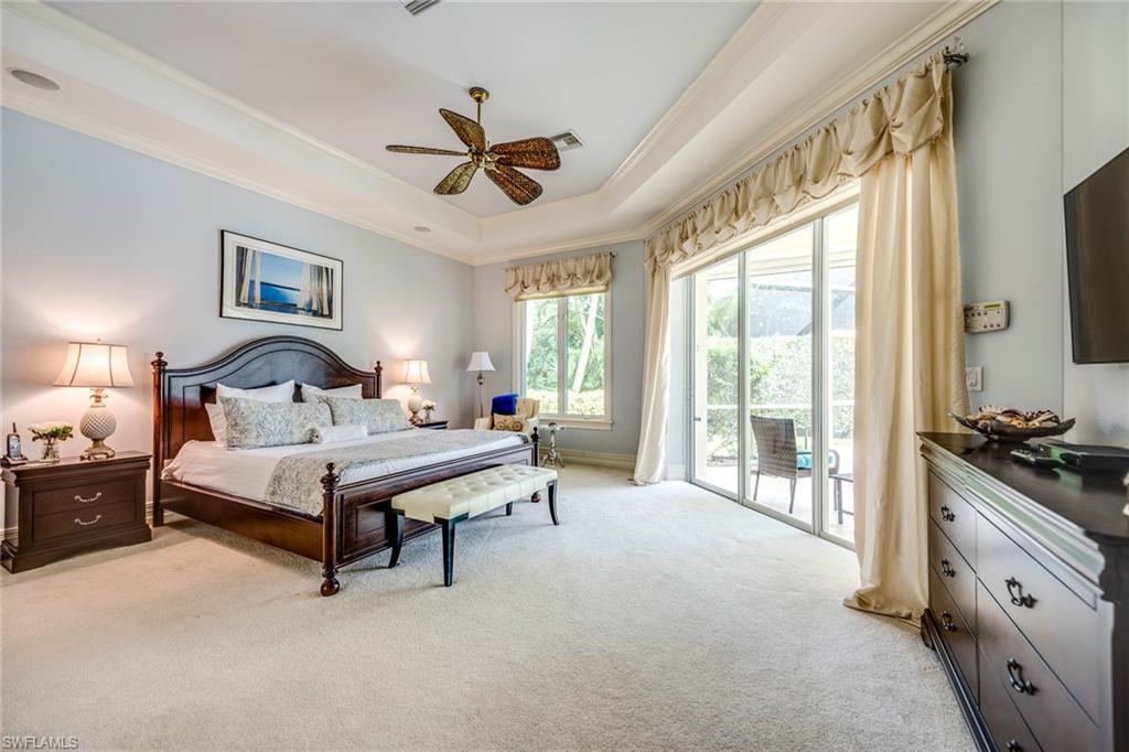 1160 Oleander Drive Naples, FL 34102 - Photo 19 of 31 a bedroom with a bed and a flat tv screen on dresser