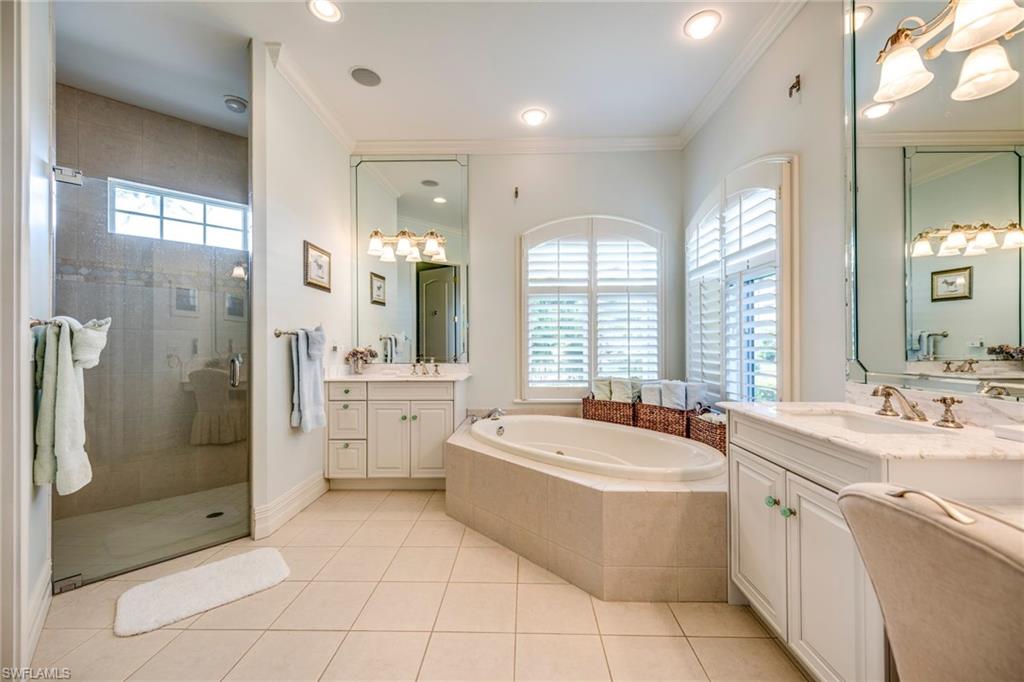 1160 Oleander Drive Naples, FL 34102 - Photo 21 of 31 a bathroom with a sink a bath tub a mirror and a shower