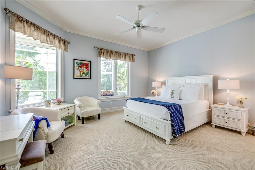 1160 Oleander Drive Naples, FL 34102 - Photo 22 of 31 a spacious bedroom with a bed and a chandelier