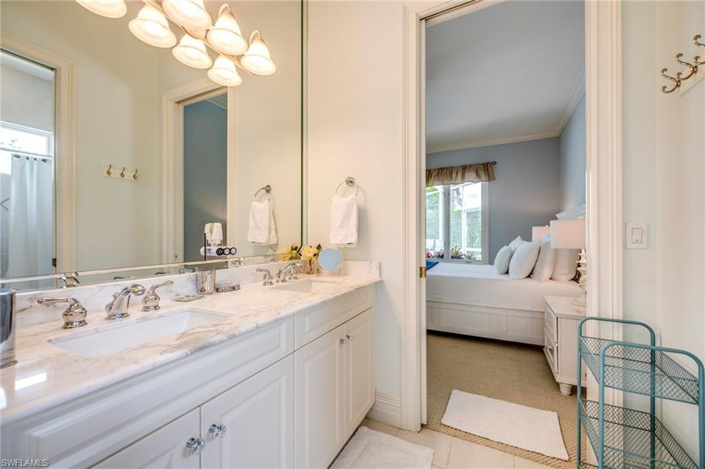 1160 Oleander Drive Naples, FL 34102 - Photo 23 of 31 a en suite bathroom with a granite countertop sink and a mirror