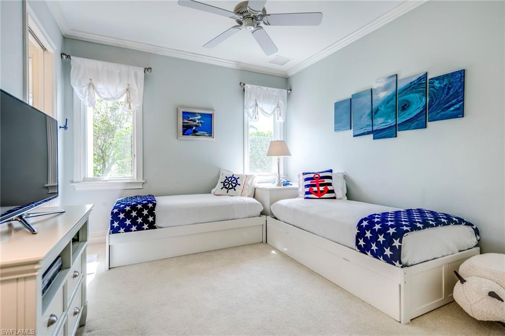 1160 Oleander Drive Naples, FL 34102 - Photo 24 of 31 a bedroom with a white bed and a chandelier