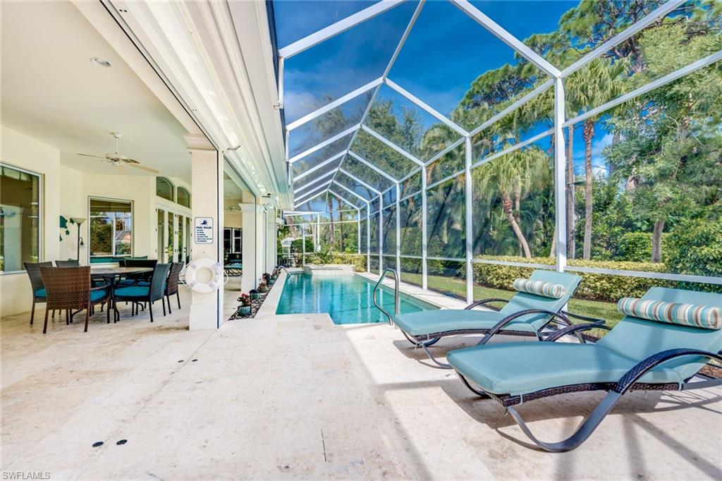 1160 Oleander Drive Naples, FL 34102 - Photo 28 of 31 a living room with patio furniture and a floor to ceiling window