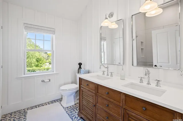 a bathroom with a sink double vanity granite and a toilet
