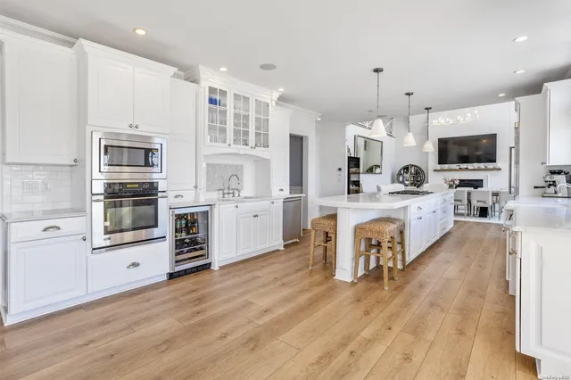 a large kitchen with kitchen island a large counter top space stainless steel appliances and cabinets