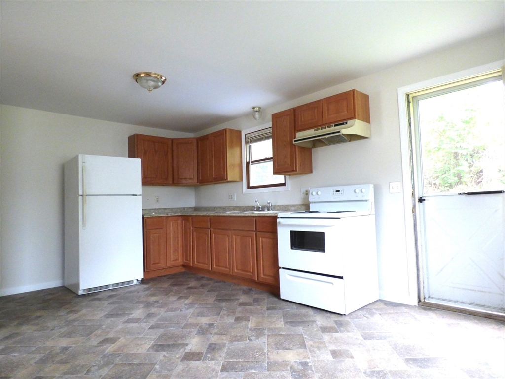 26-28 Daniel Street Springfield, MA 01151 - Photo 7 of 15 a kitchen with a stove top oven cabinets and a refrigerator